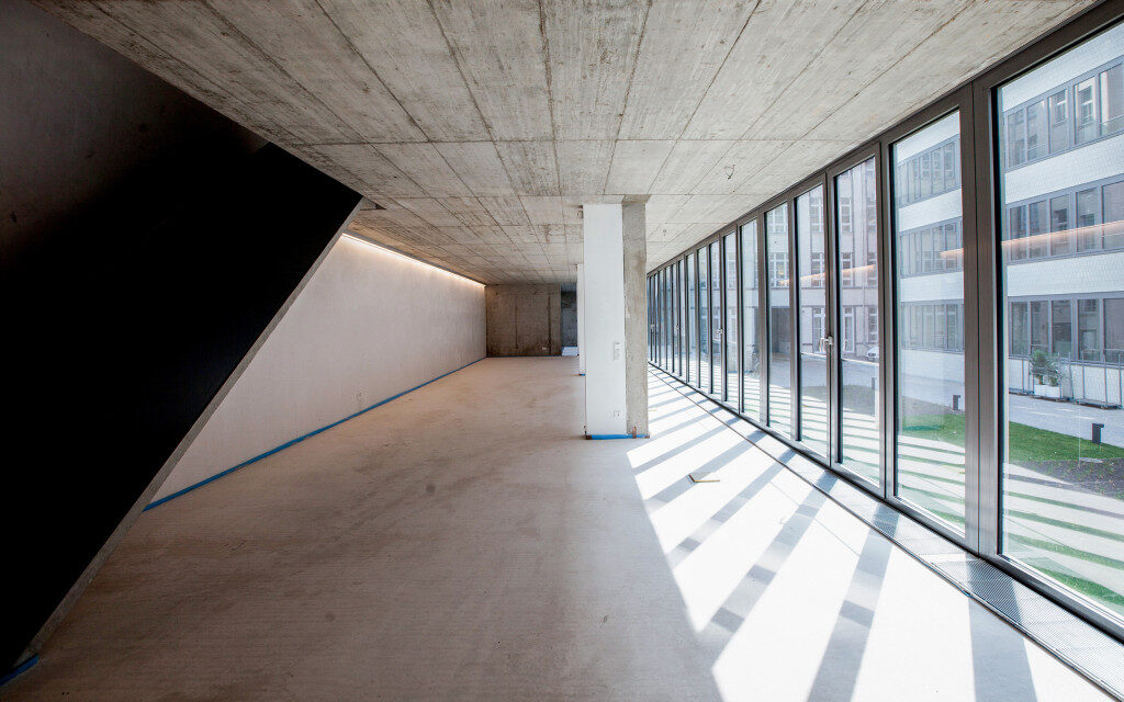 Glasfront Sichtbeton leere Bürofläche